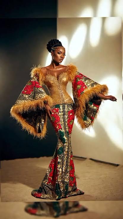 woman posing center-frame in a highly structured, floor-length Ankara couture mermaid gown. 